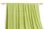 JL12-036 — Matte Single Jersey Nylon Spandex Fabric — hanging fabric on wooden bar