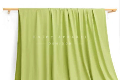 JL12-036 — Matte Single Jersey Nylon Spandex Fabric — hanging fabric on wooden bar