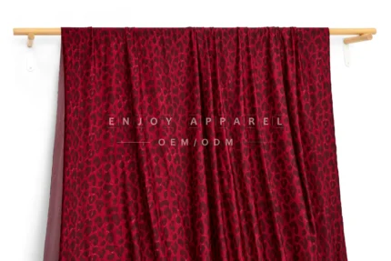 JL01-039-LEO — Leopard Print Warp Knit Fabric — hanging fabric on wooden bar