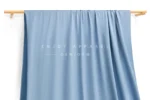 JL0088 — Lustrous Warp Knit Nylon Swim Fabric — hanging fabric on wooden bar